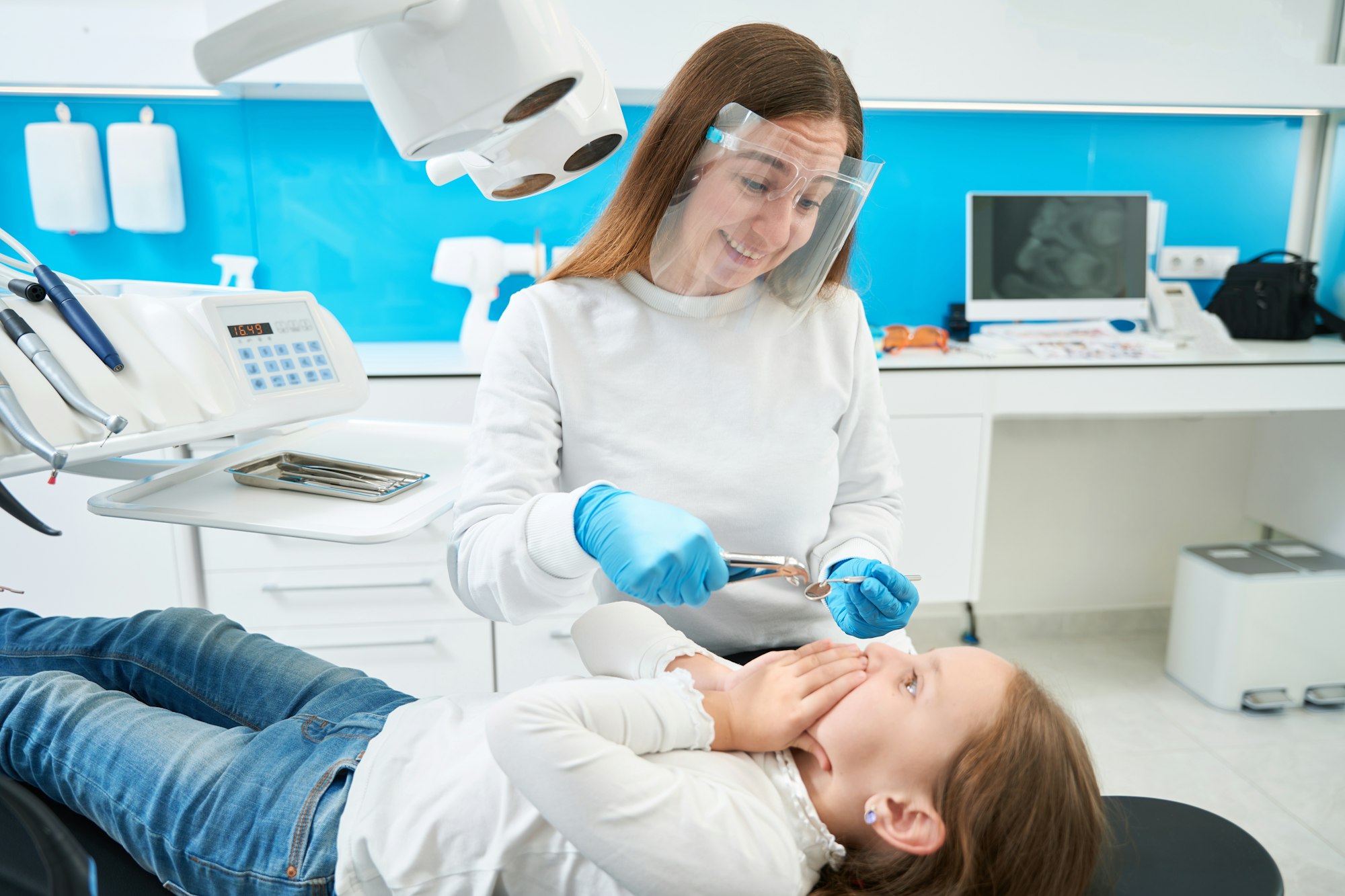 Dental surgeon laughing at capricious little patient